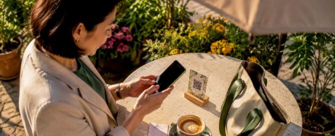Woman scanning QR code at café table