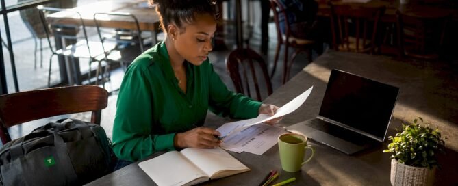 Woman reviewing tip income documents at home desk