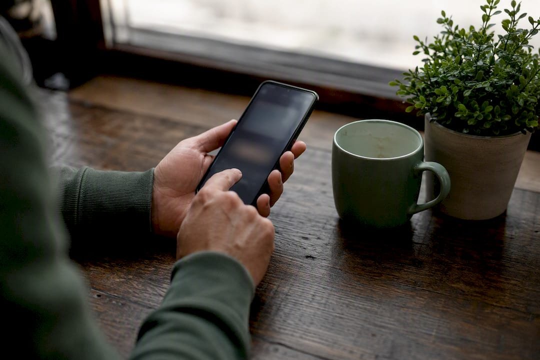 Hand poised to tap mobile wallet pay button