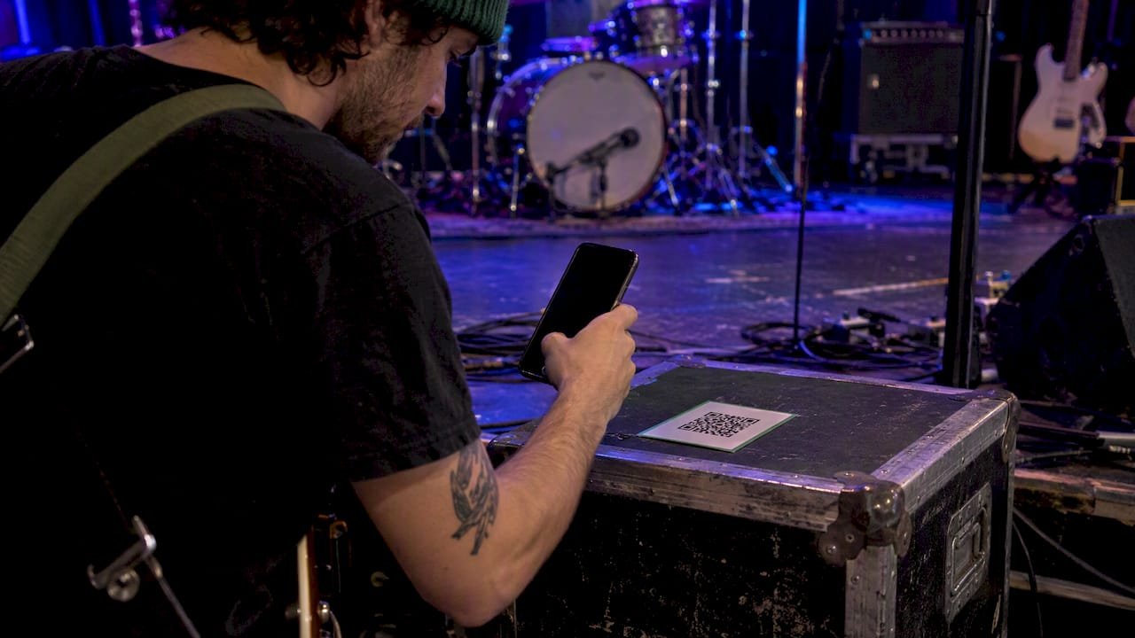 Musician testing QR code under stage lights